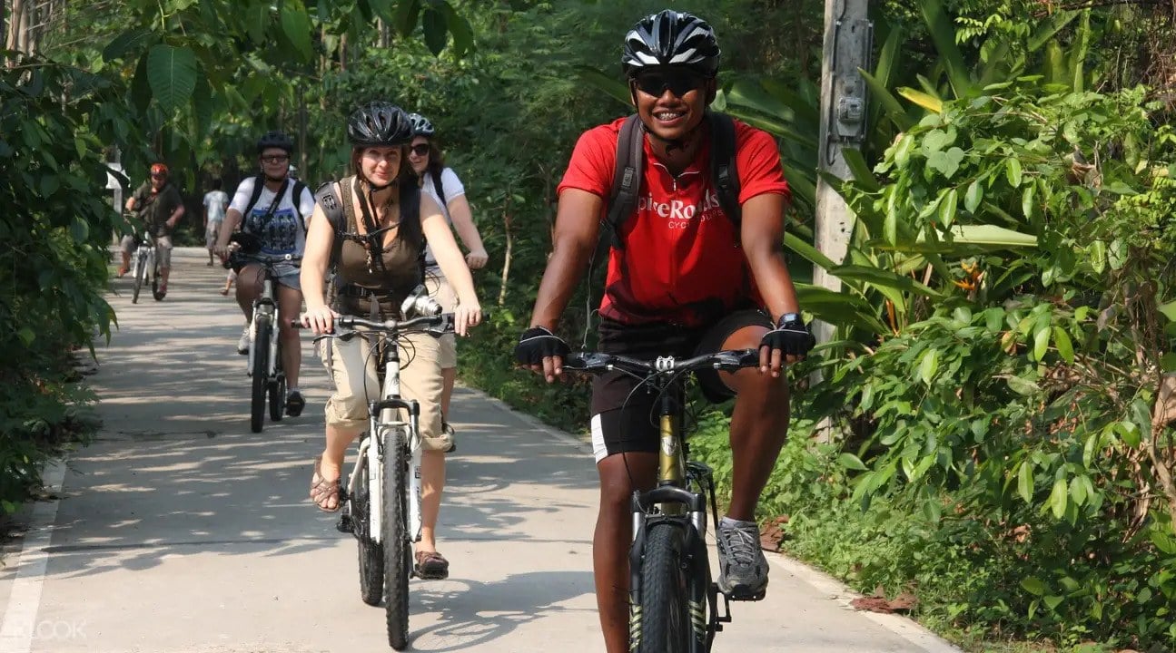 Die Leute reisen Fahrräder durch den Dschungel von Bangkok.