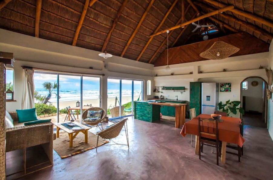 Offenes Strandhaus mit Sand und blauem Meer direkt vor dem Fenster Was ist Airbnb