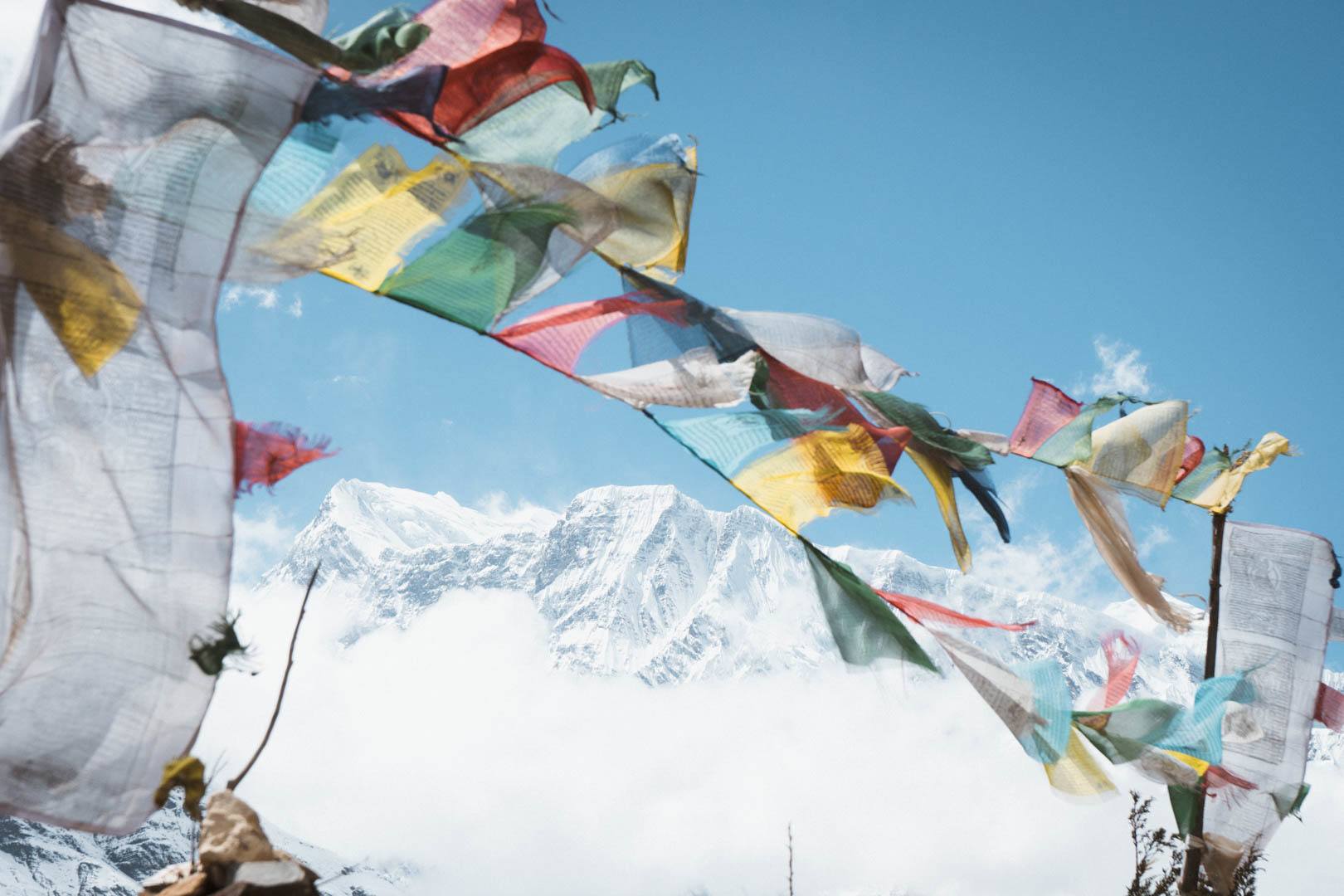 Ein schneebedeckter Himalay a-Gipfel mit tibetischen Gebetsflaggen