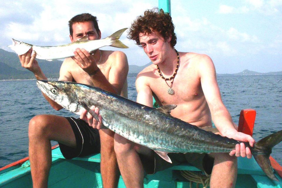 Zwei Jungs halten Fische am Ufer des Pazifischen Ozeans.