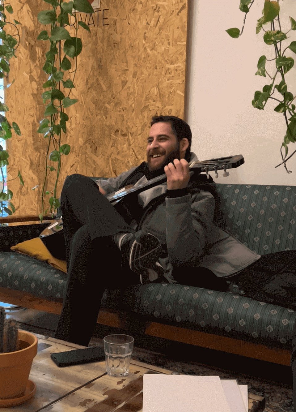 Typ spielt Gitarre in einem Hostel