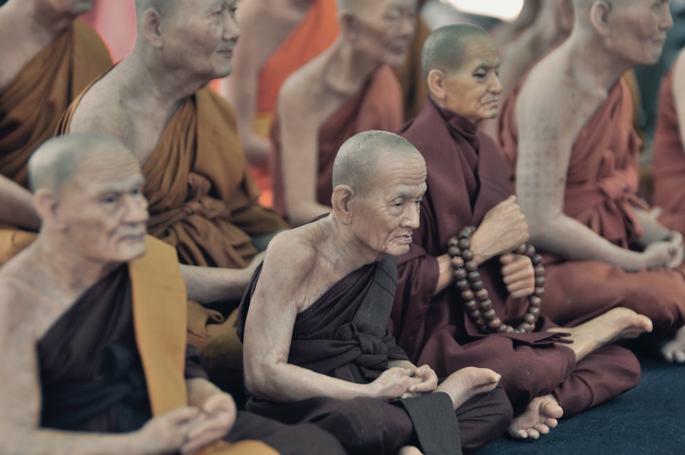 Mönche sitzen auf dem Boden und beten