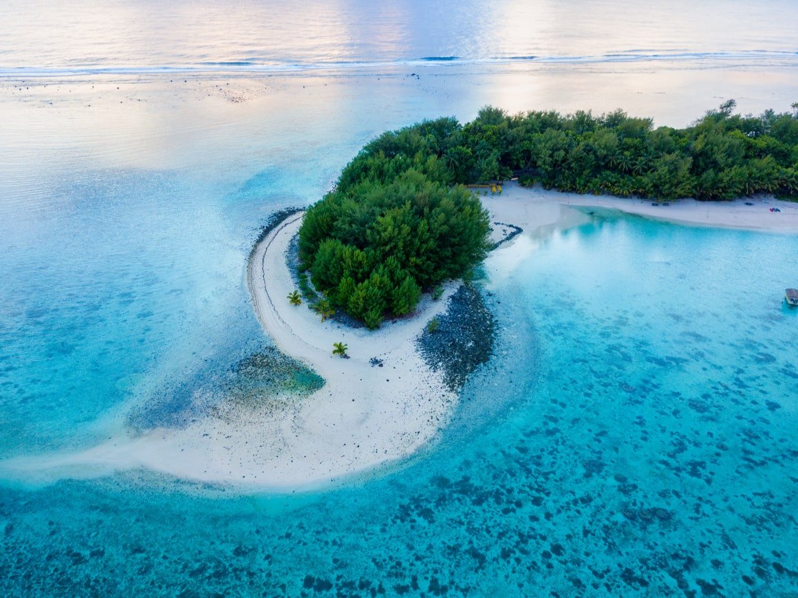 Transparent Blauwasser umgibt die prächtige grüne Insel im Pazifik.