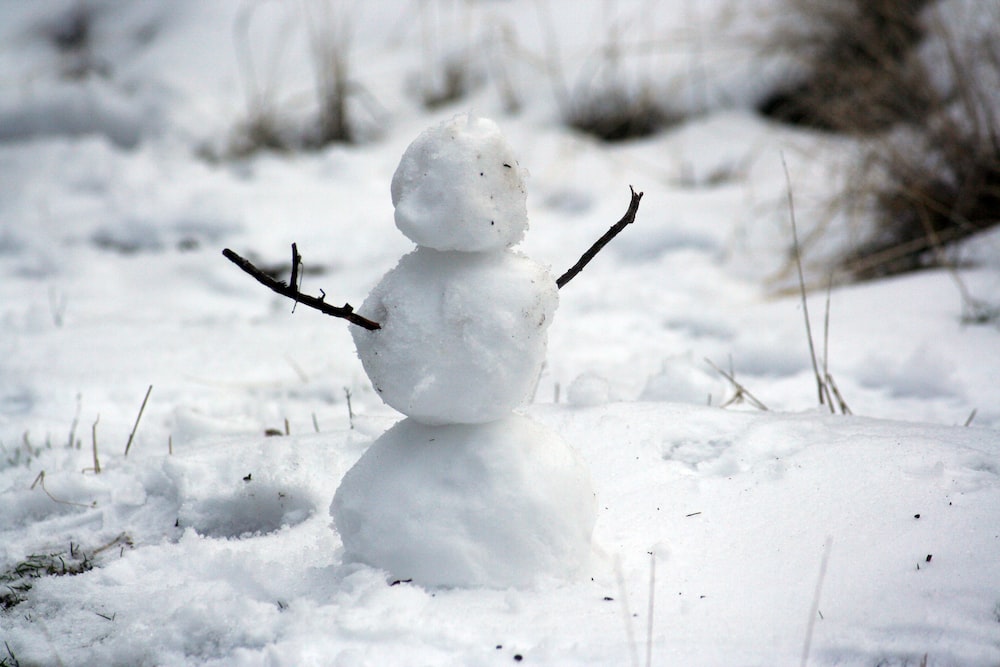 Foto eines Schneemanns mit Händeschlägen im Schnee