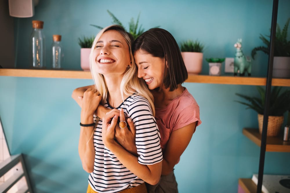 Zwei Mädchen lachen und umarmen sich