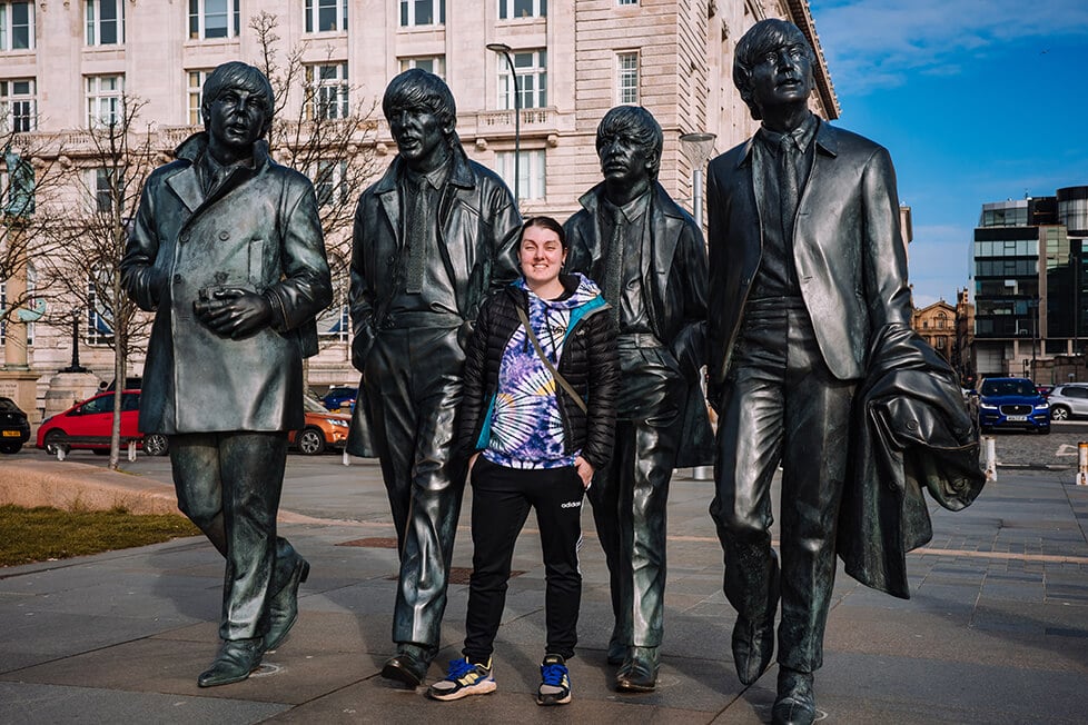 Eine Person steht vor der Statue der Beatles in Liverpool