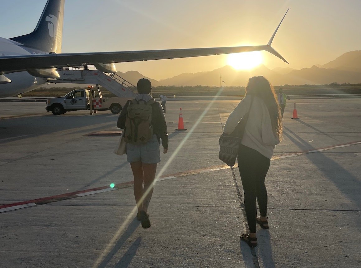 Zwei Mädchen gehen bei Sonnenuntergang in Mexiko zum Flugzeug
